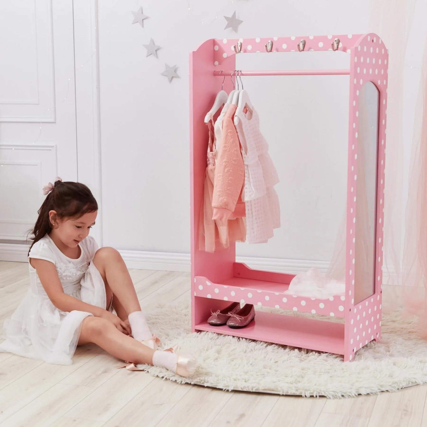 Girl Wearing Socks Next to Fantasy Fields Kids Polka Dots Clothing Rack with Storage Pink