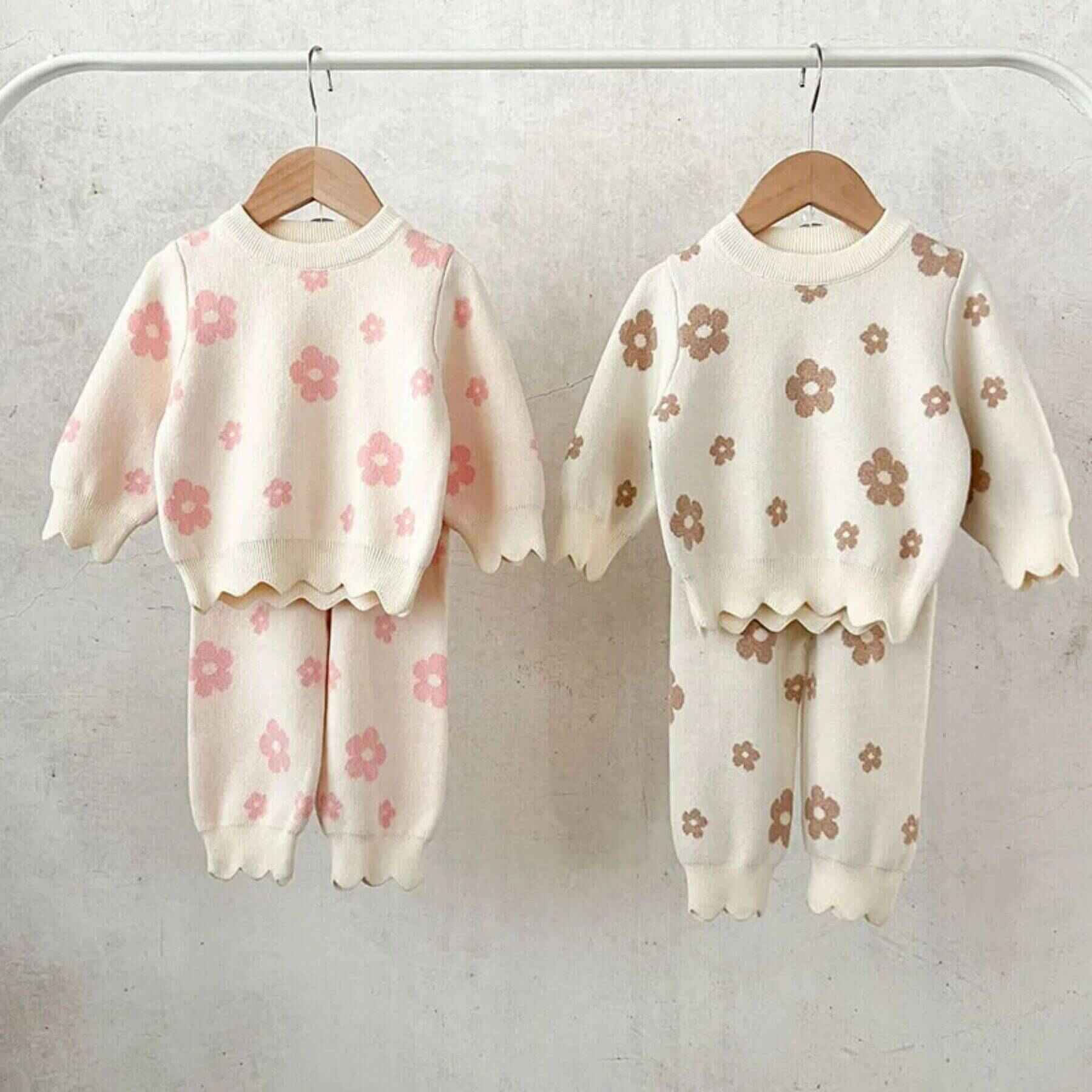 Two Flower Power Knitted Set hanging on a rack against a light background.