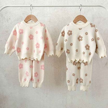 Two Flower Power Knitted Set hanging on a rack against a light background.