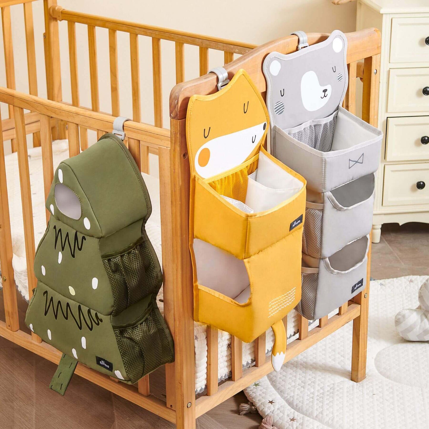 Forest Friends Hanging Organizers hanging on a wooden crib in a nursery.