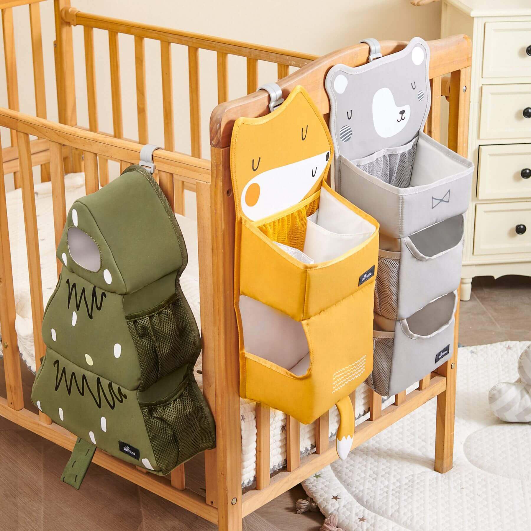 Forest Friends Hanging Organizers hanging on a wooden crib in a nursery.