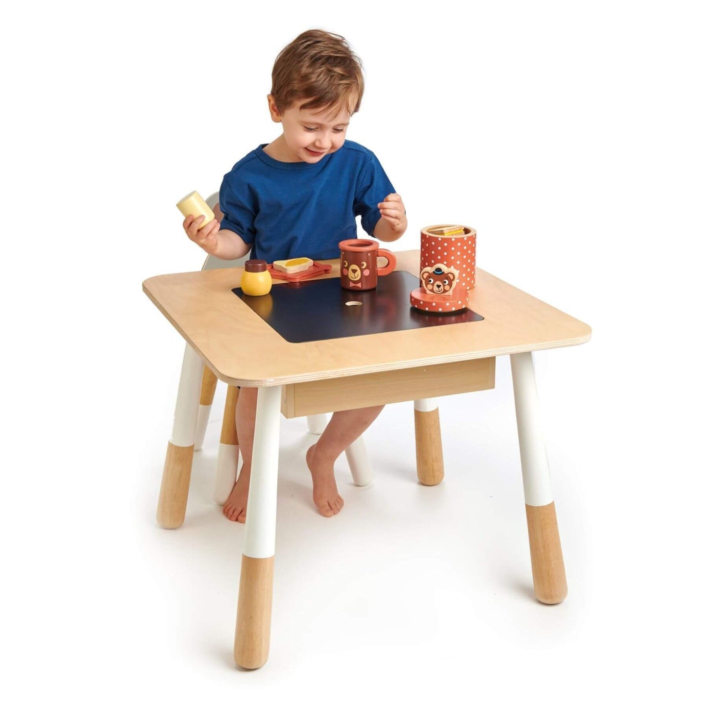 Child playing at Tender Leaf Forest Table with colorful toys on a white background