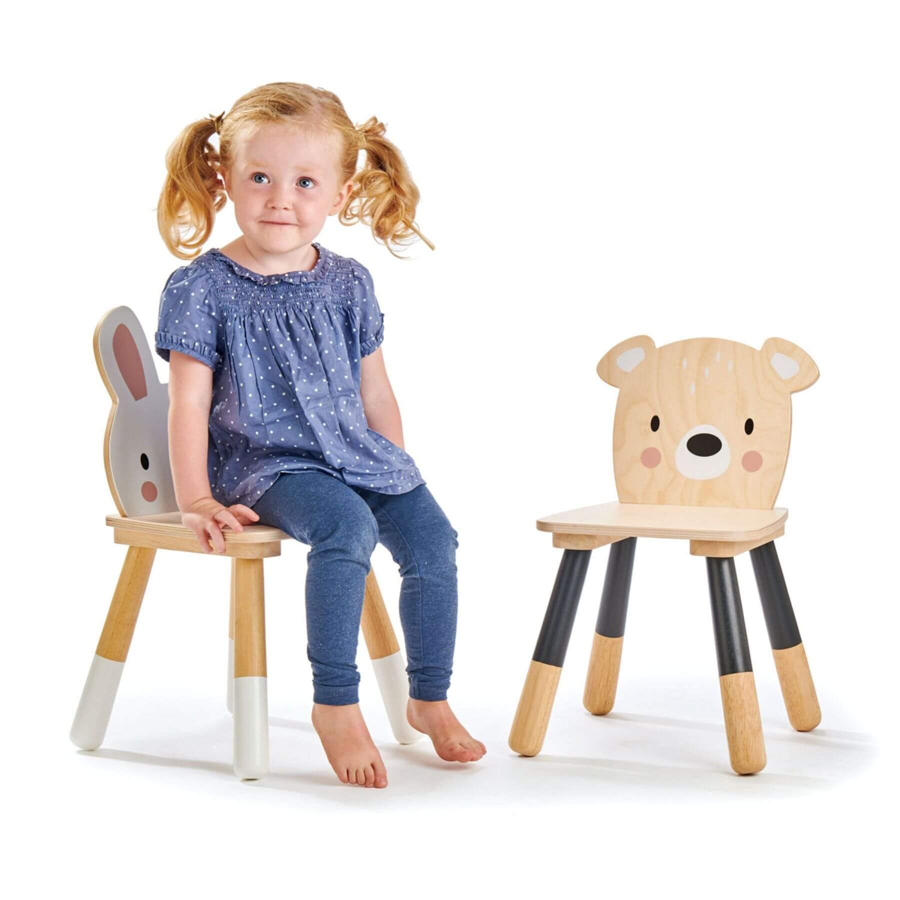 Child sitting on a rabbit chair next to bear chair on a white background