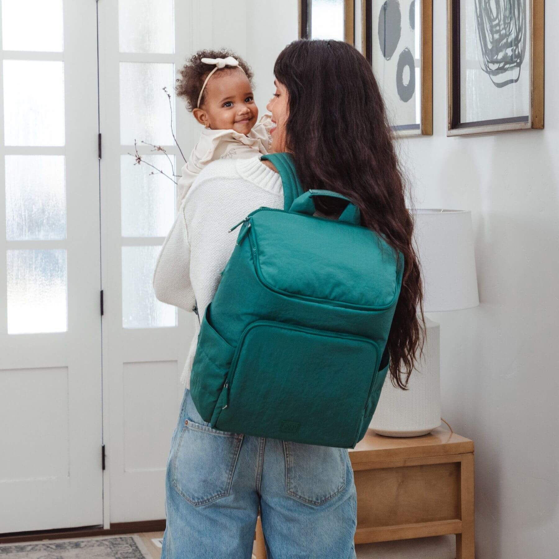 Woman carrying a Forest Zurich Diaper Bag with a child indoors