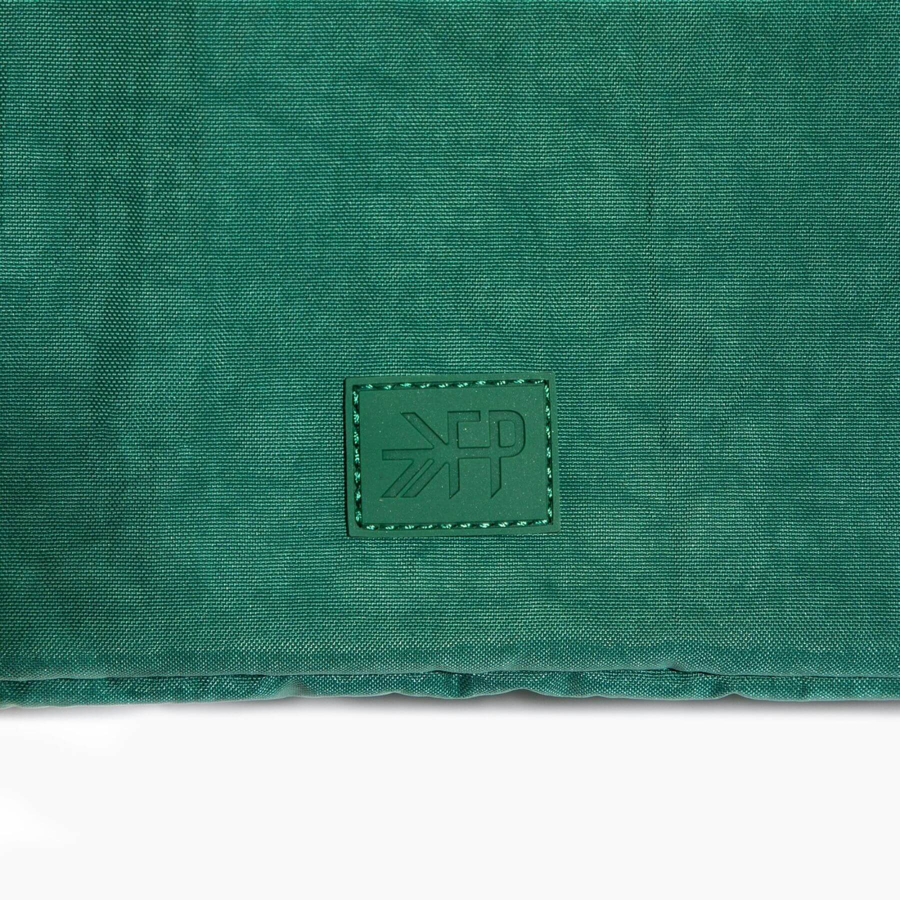 Green fabric surface with a brand logo in the center