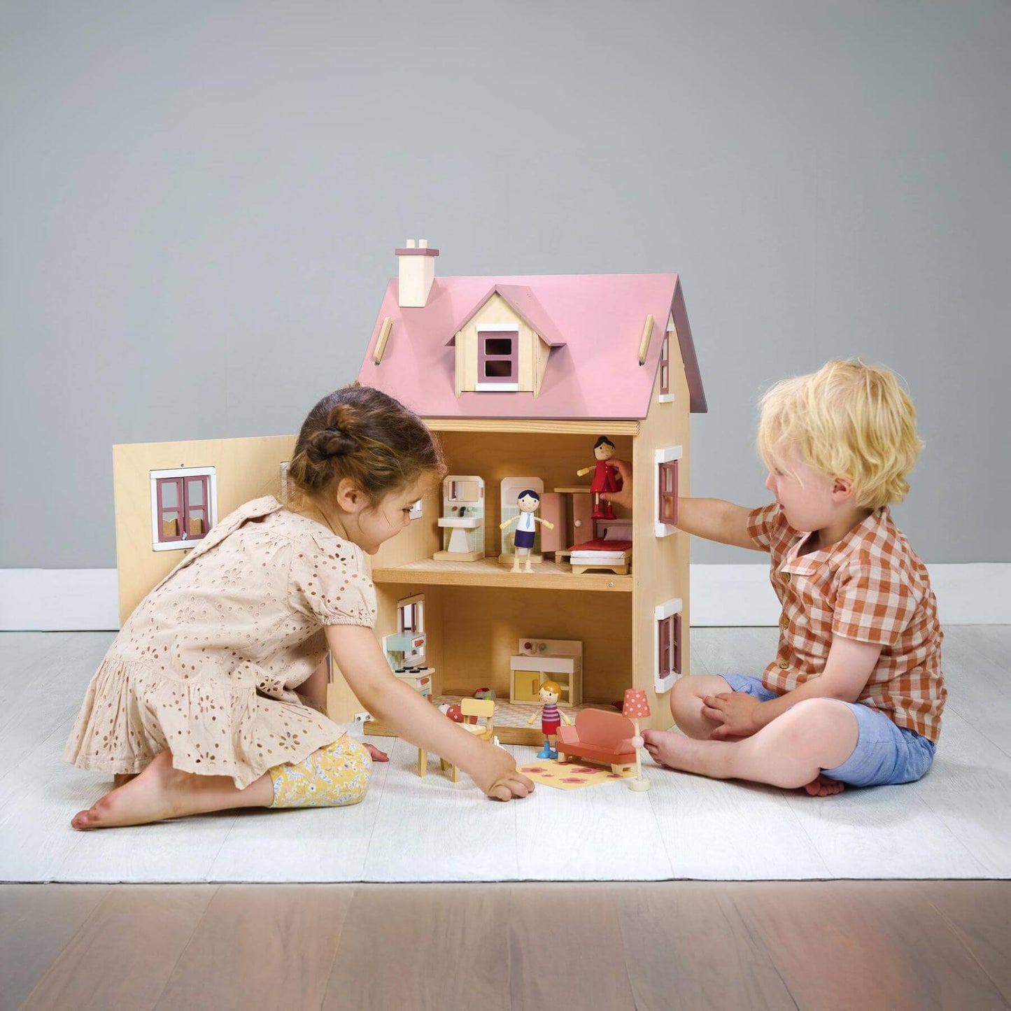 Two children playing with Tender Leaf Foxtail Villa Pink on a plain background