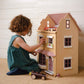 Child playing with Tender Leaf Foxtail Villa Pink on a carpeted floor.