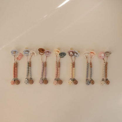 Row of colorful baby teething toys on a beige background