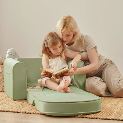 Woman and child sitting on Tiny Land® GentleSnug Kid Chair Sage reading a book together.