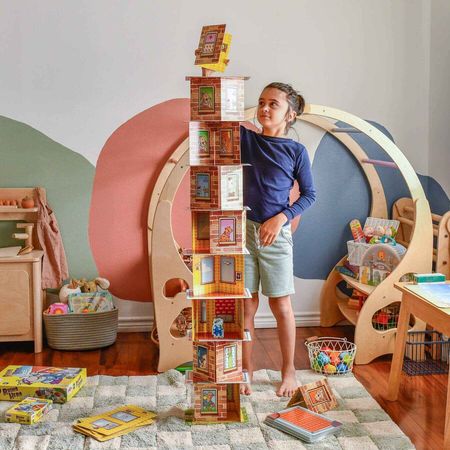 Child playing with Giant Rhino Hero XXL Stacking Cards Game in a colorful room