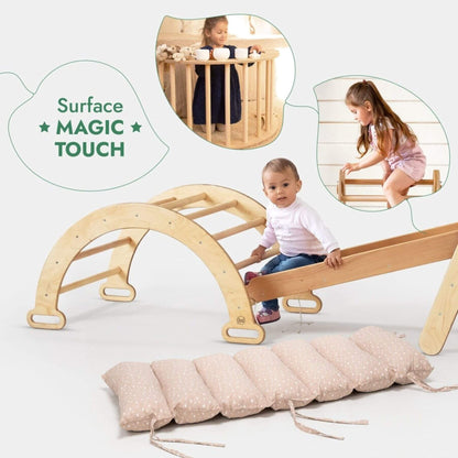 Natural wood toddler climbing and sliding play structure with a matching padded floor cushion. Two inset photos show children using the play structure, and text reads 'Surface MAGIC TOUCH'.