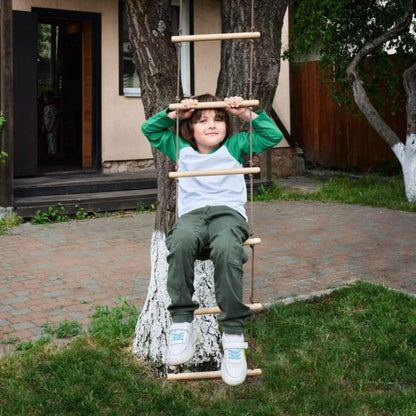 Child sitting on Goodevas Climbing Rope Ladder in a backyard
