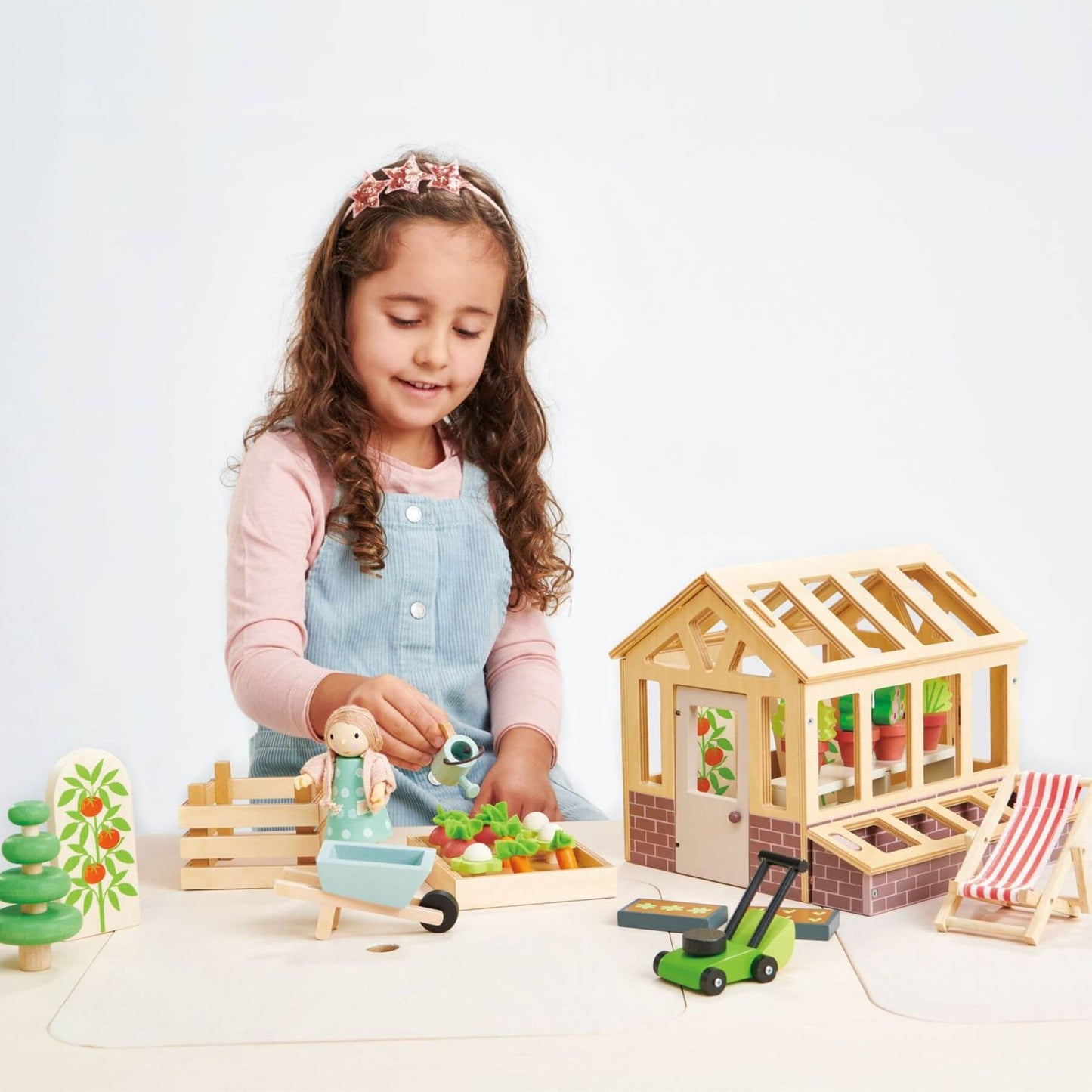 Child playing with Tender Leaf Greenhouse and Garden Set on a white background