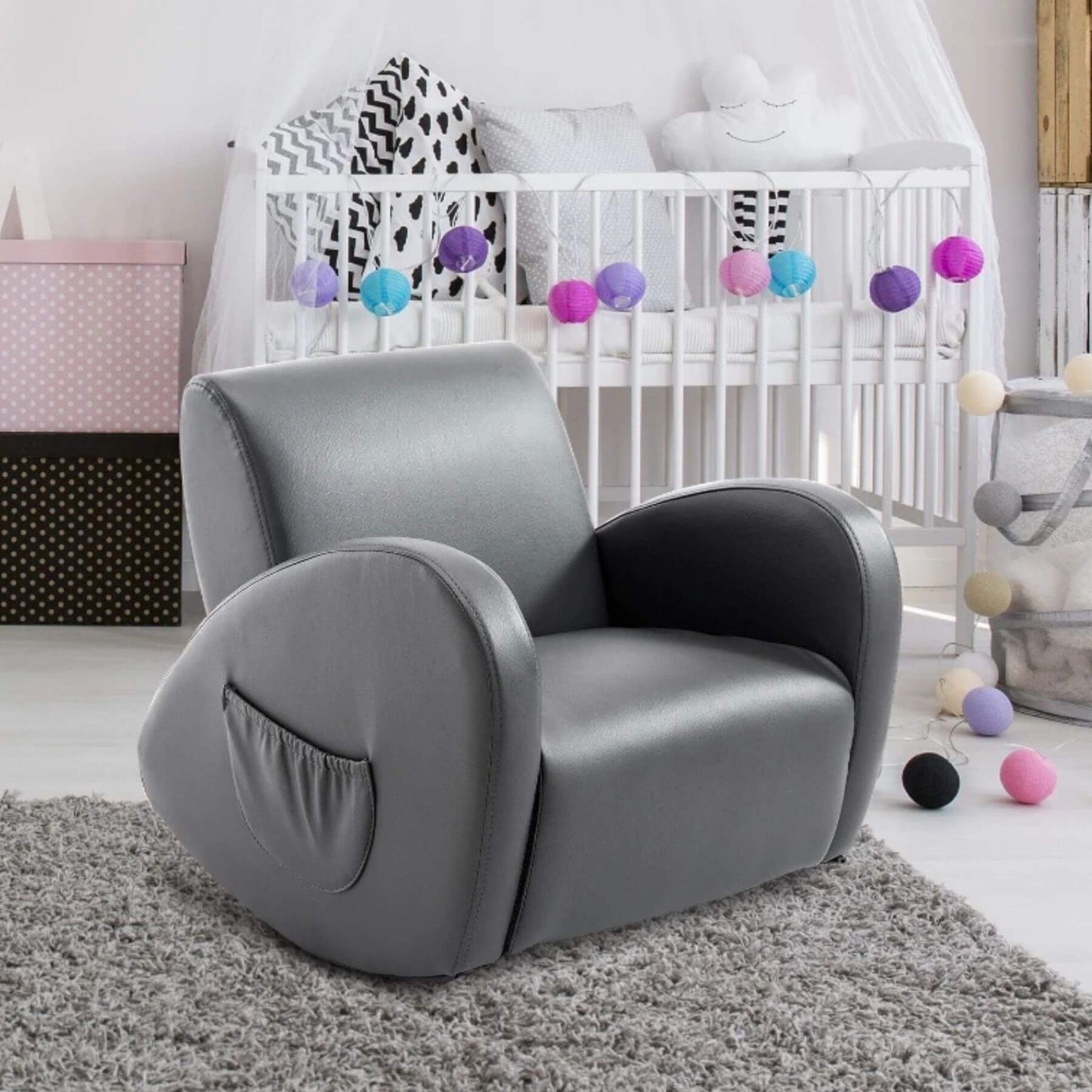 Qaba PU Leather Kids Sofa Rocking Chair Grey in a nursery with a crib and colorful balls in the background.