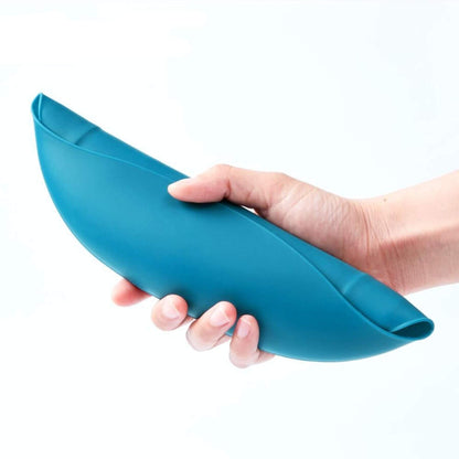 Hand holding a blue silicone bib on a white background