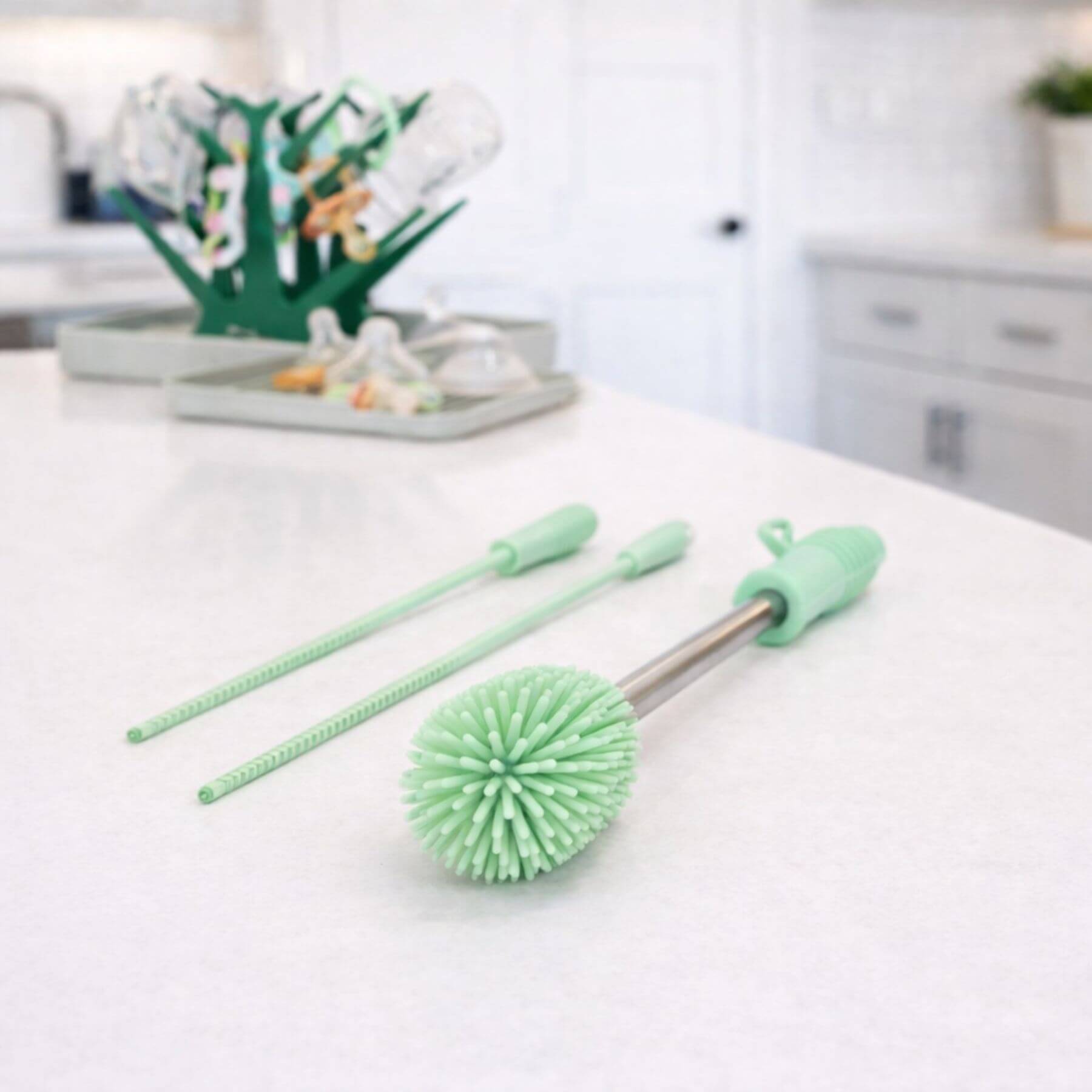 Green cleaning brush set on a kitchen counter with a blurred background