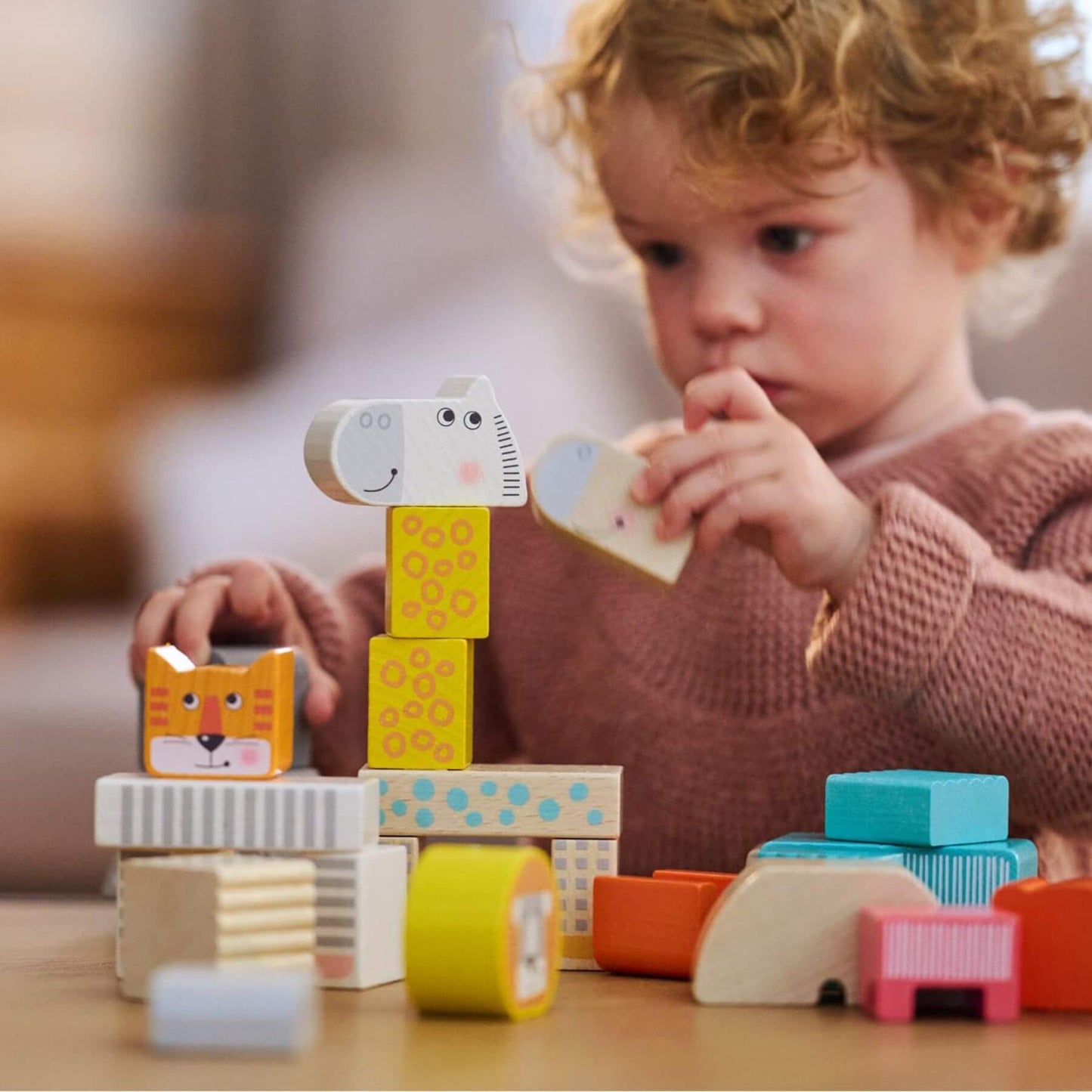 Child playing with HABA USA Animal Parade Blocks on a table
