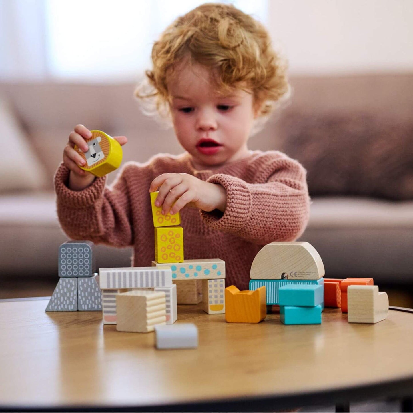Child playing with HABA USA Animal Parade Blocks on a table