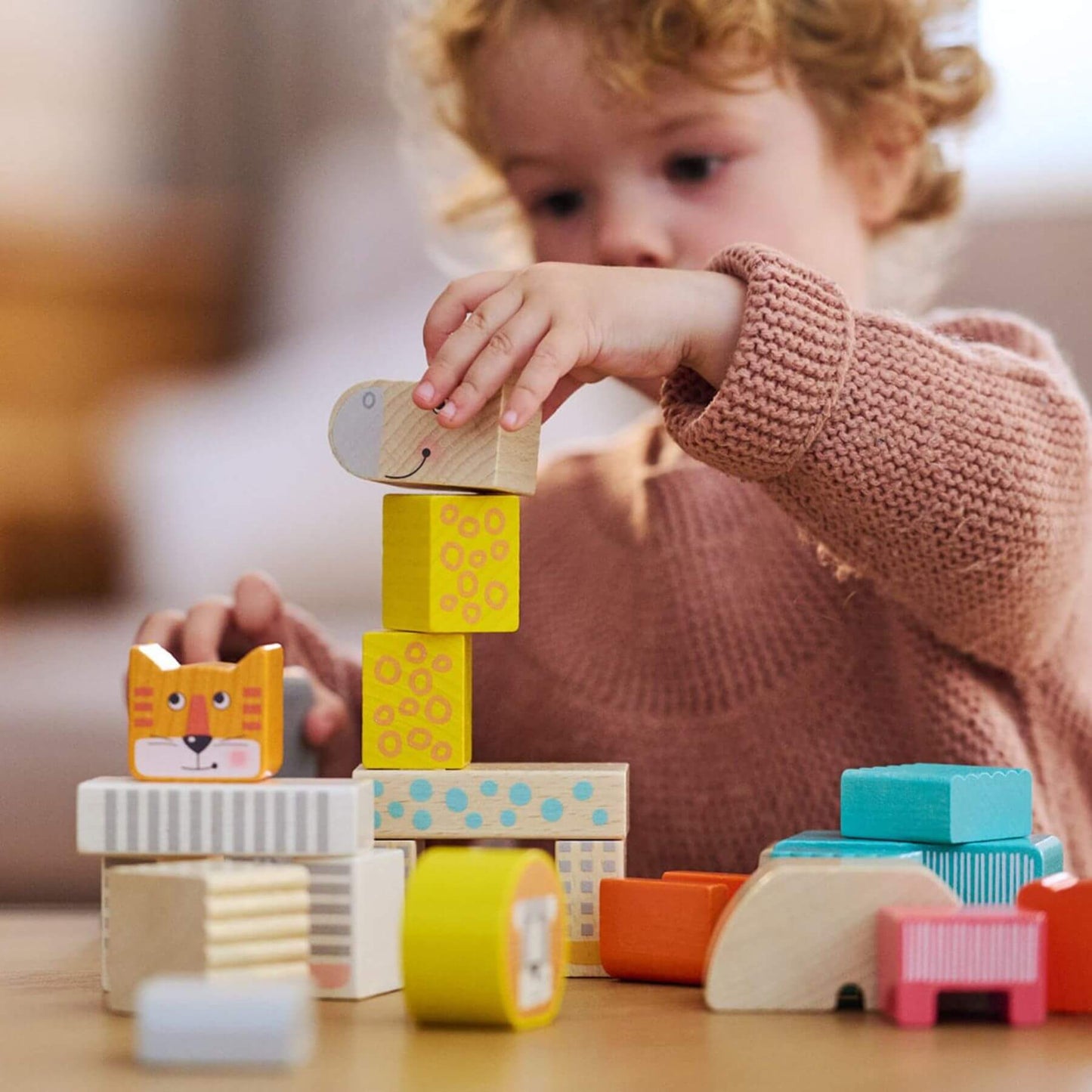 Child playing with HABA USA Animal Parade Blocks on a table