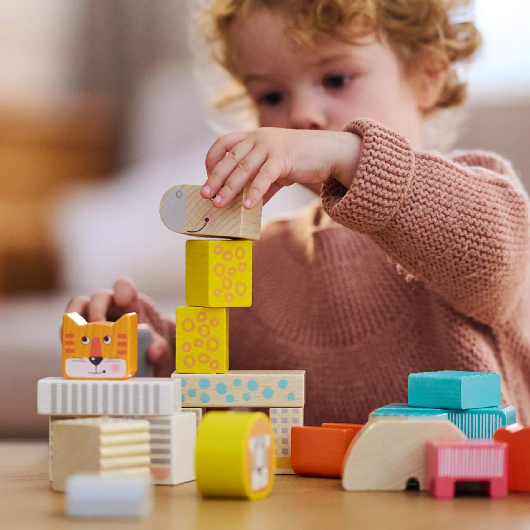 Child playing with HABA USA Animal Parade Blocks on a table