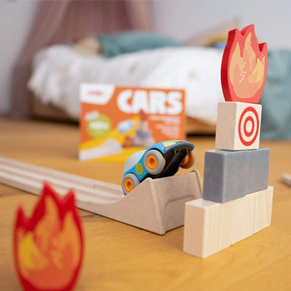 Toy car on a track with wooden blocks and fire designs in a casual setting