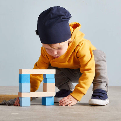 Child playing with colorful blocks on a wooden floor
