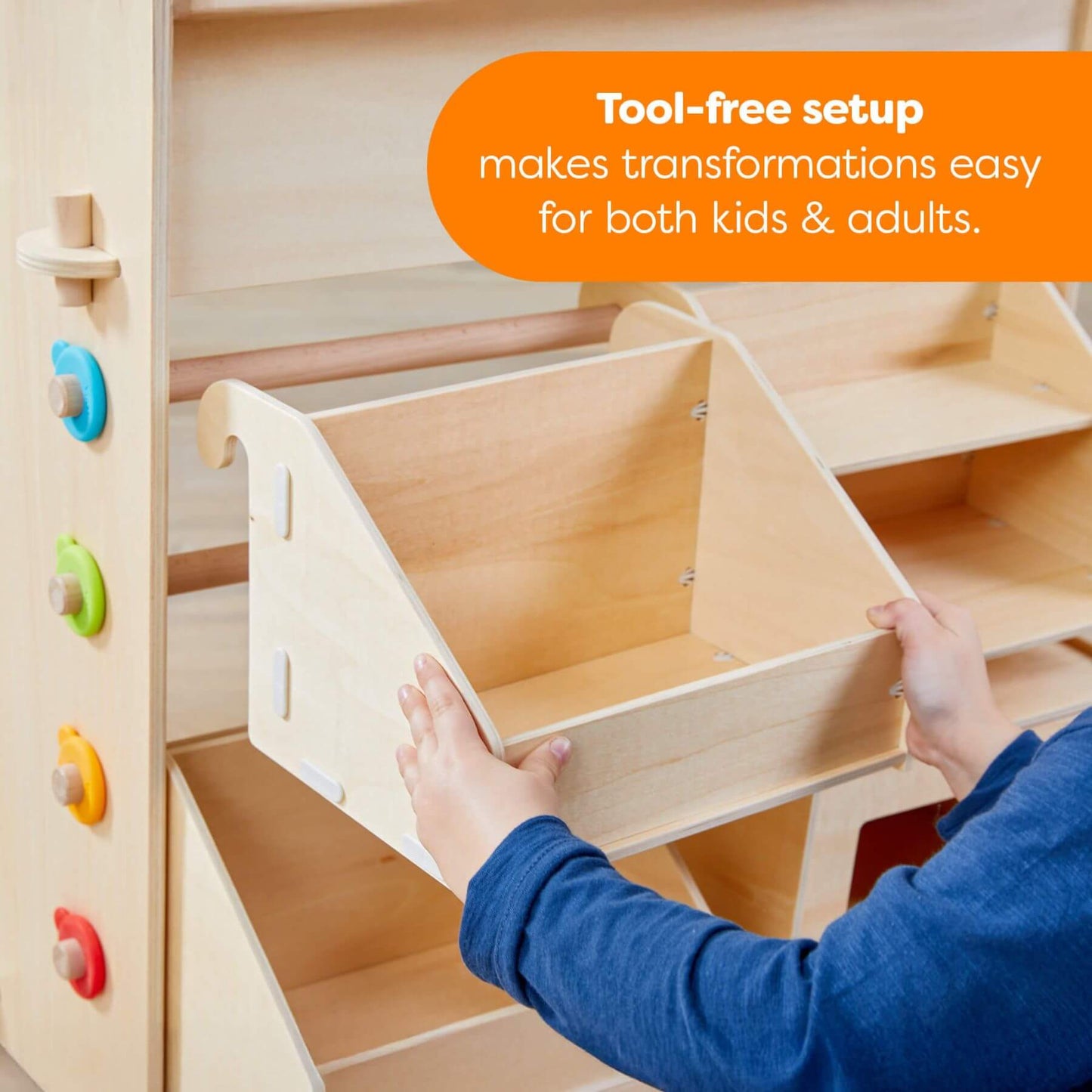 Wooden toy structure with colorful knobs, being assembled by a person in a blue shirt.
