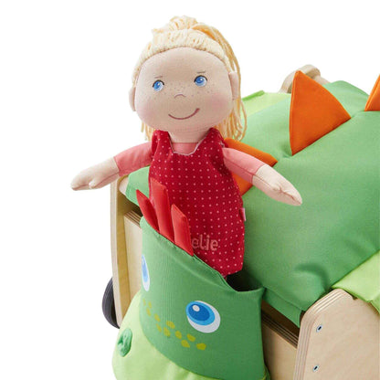 Toy doll with blonde hair and blue eyes inside a green dinosaur-shaped toy