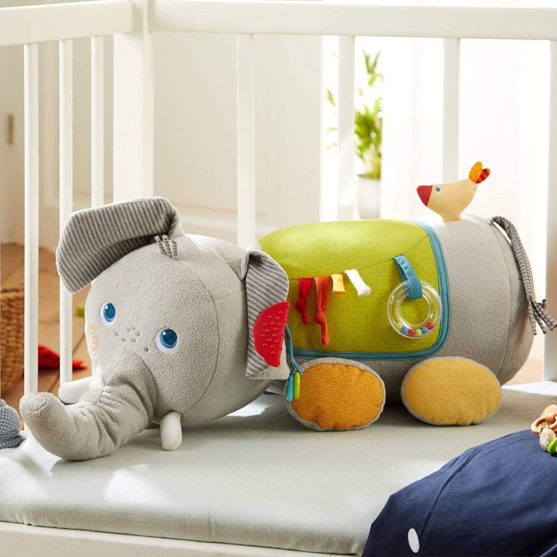 HABA USA Elephant Discovery Pillow on a crib.