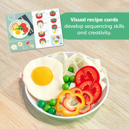 Colorful plate of play food with visual recipe cards on a wooden surface