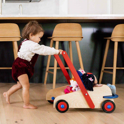Child playing with HABA USA Walker Wagon Push Toy in a kitchen