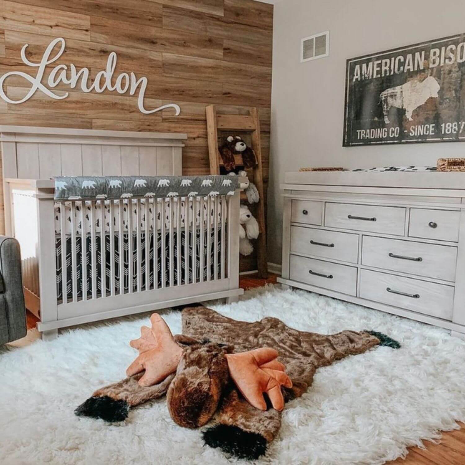 Nursery room with wooden wall, crib, and decorative elements.