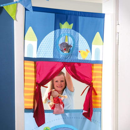 Child playing with a colorful puppet theater