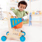 Child playing with Hape Shopping Cart in a colorful room