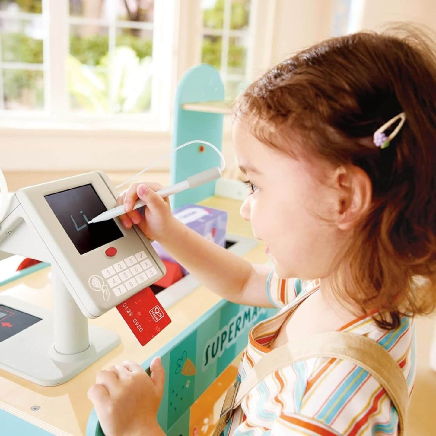 Child playing Hape Smart & Wooden Supermarket