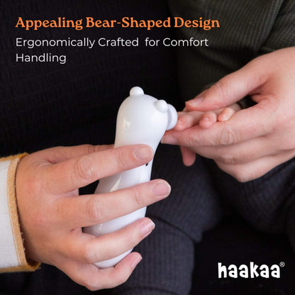 Haakaa Happii Bear Rechargeable Nail Trimmer being held by hands with text about its design and brand 'haakaa'.