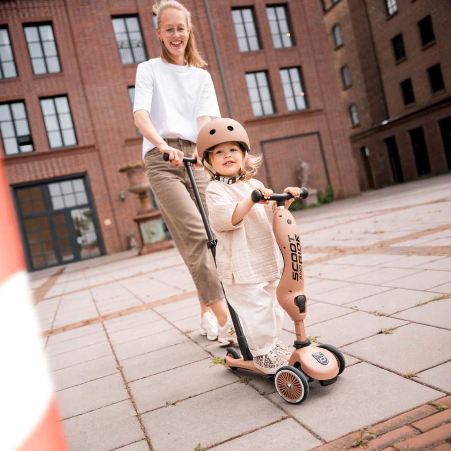 Woman and child with a scooter in an urban setting