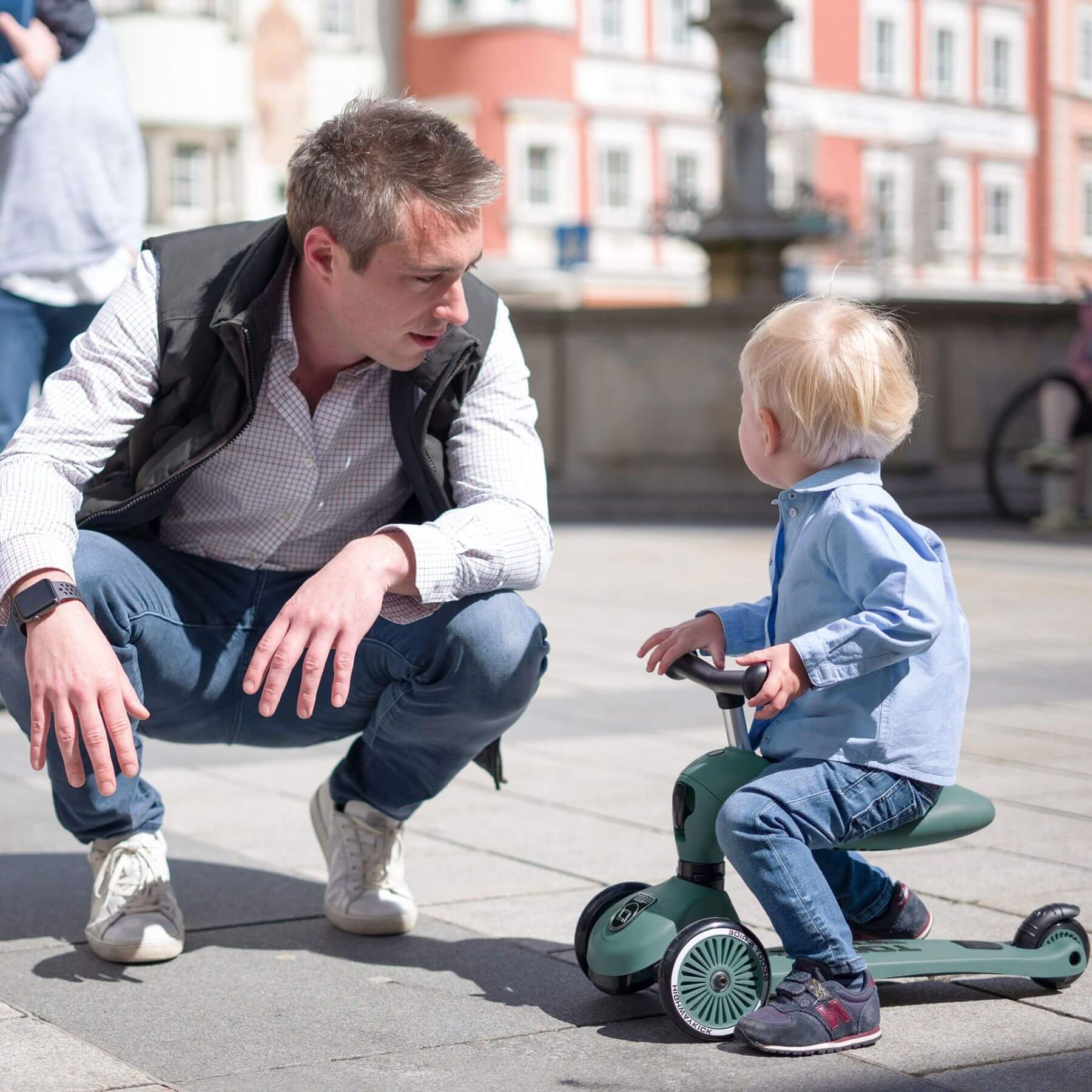 Man and child with a scooter in an urban setting