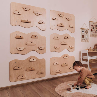 Child playing on a rug with wooden climbing structures on the wall