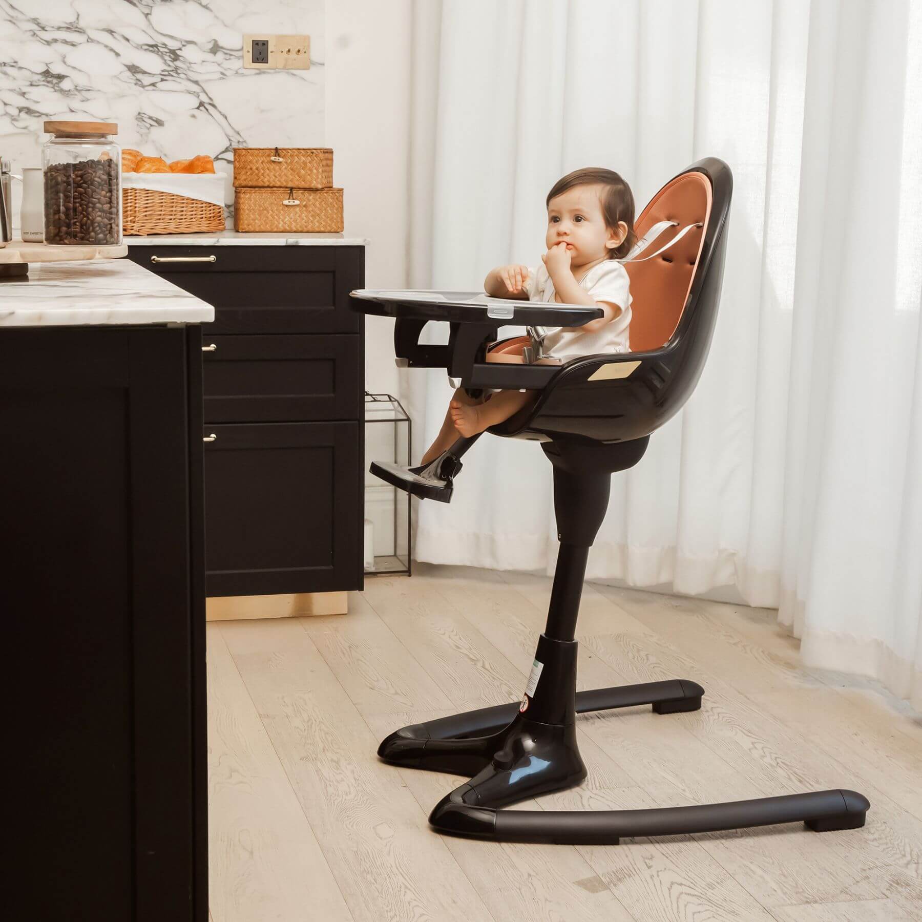 Child sitting in Hot Mom High Chair - Black Gold at a kitchen counter.