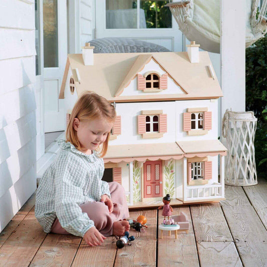 Child playing with Tender Leaf Humming Bird House on a wooden deck.