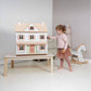 Child playing with Tender Leaf Humming Bird House on a table in a room with a rocking horse.