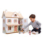 Child playing with Tender Leaf Humming Bird House and figurines on a white background