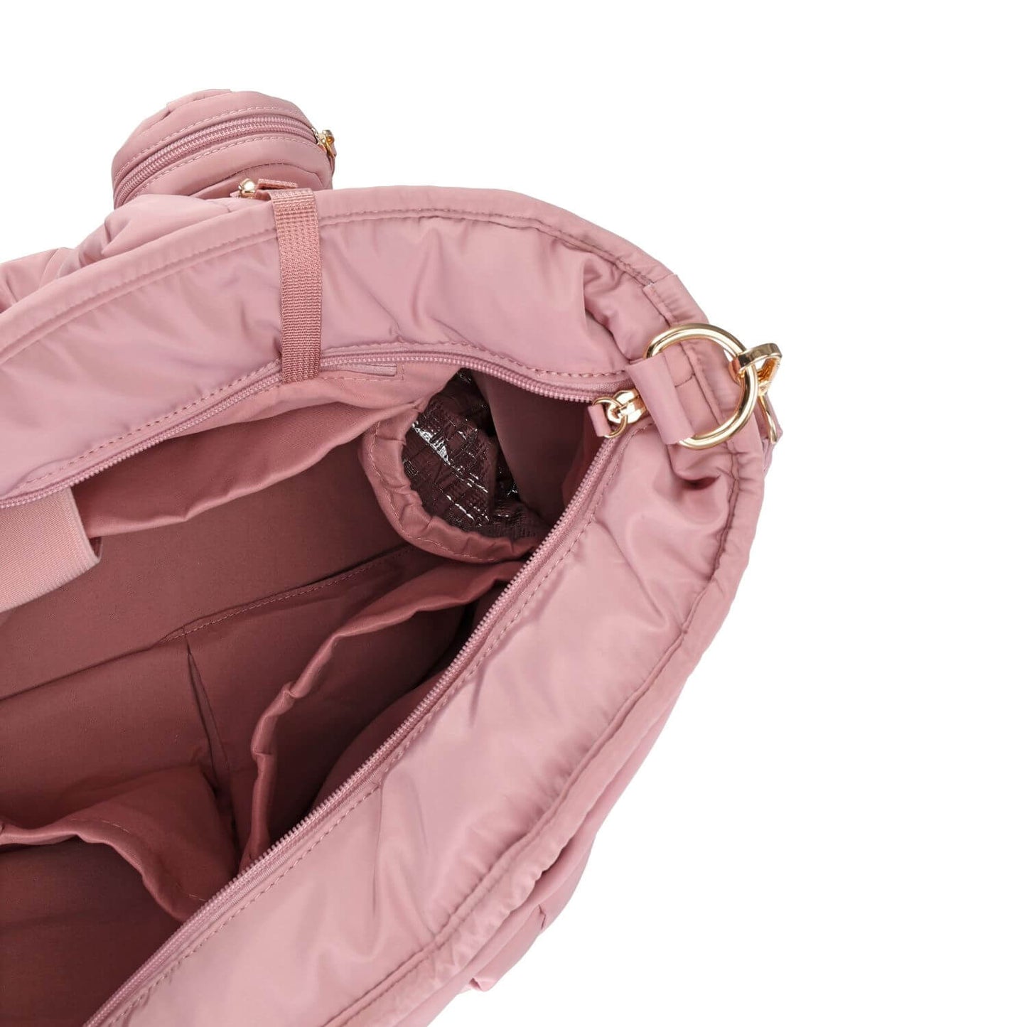 Close-up of Luli Bebé Infinite Diaper Bag - Blush showing the interior lining, zipper compartments, and gold-tone hardware against a white background.
