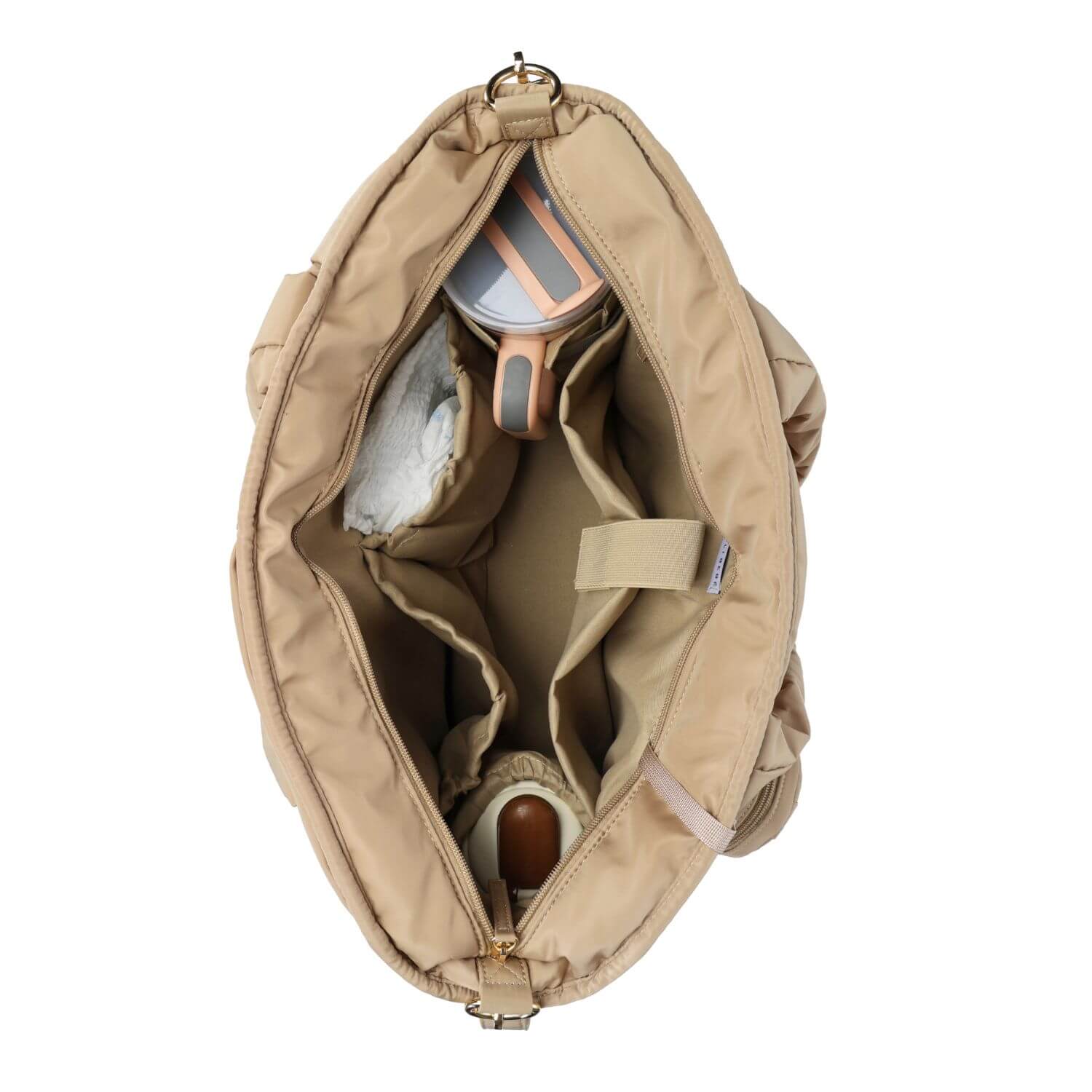 A top-down view of Luli Bebé Infinite Diaper Bag - Latte opened to show its interior storage compartments, with a diaper holder, a cup, and a diaper pocket visible against a white background.