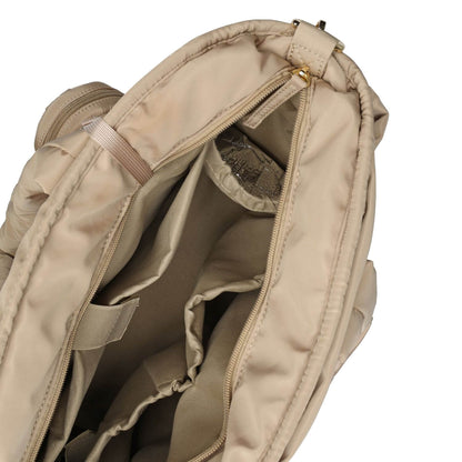 Close-up of the interior of Luli Bebé Infinite Diaper Bag - Latte, showing the padded compartment, zipper, and internal organization pockets against a white background.