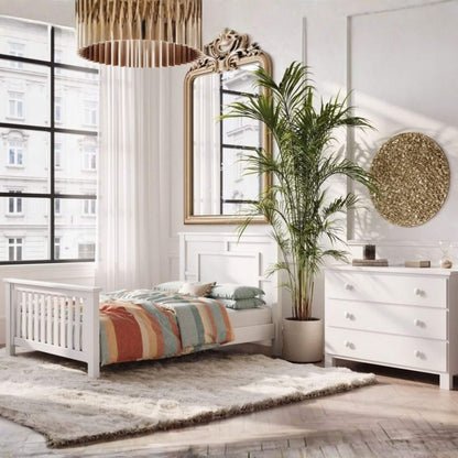 Modern bedroom with white furniture, colorful bedding, and decorative elements.