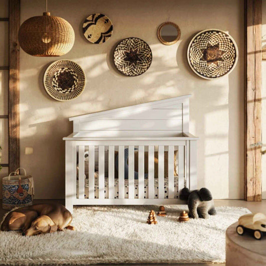 Nursery room with "Just White"  Balanced Baby Convertible Crib, decorative baskets on the wall, and toys on the floor.
