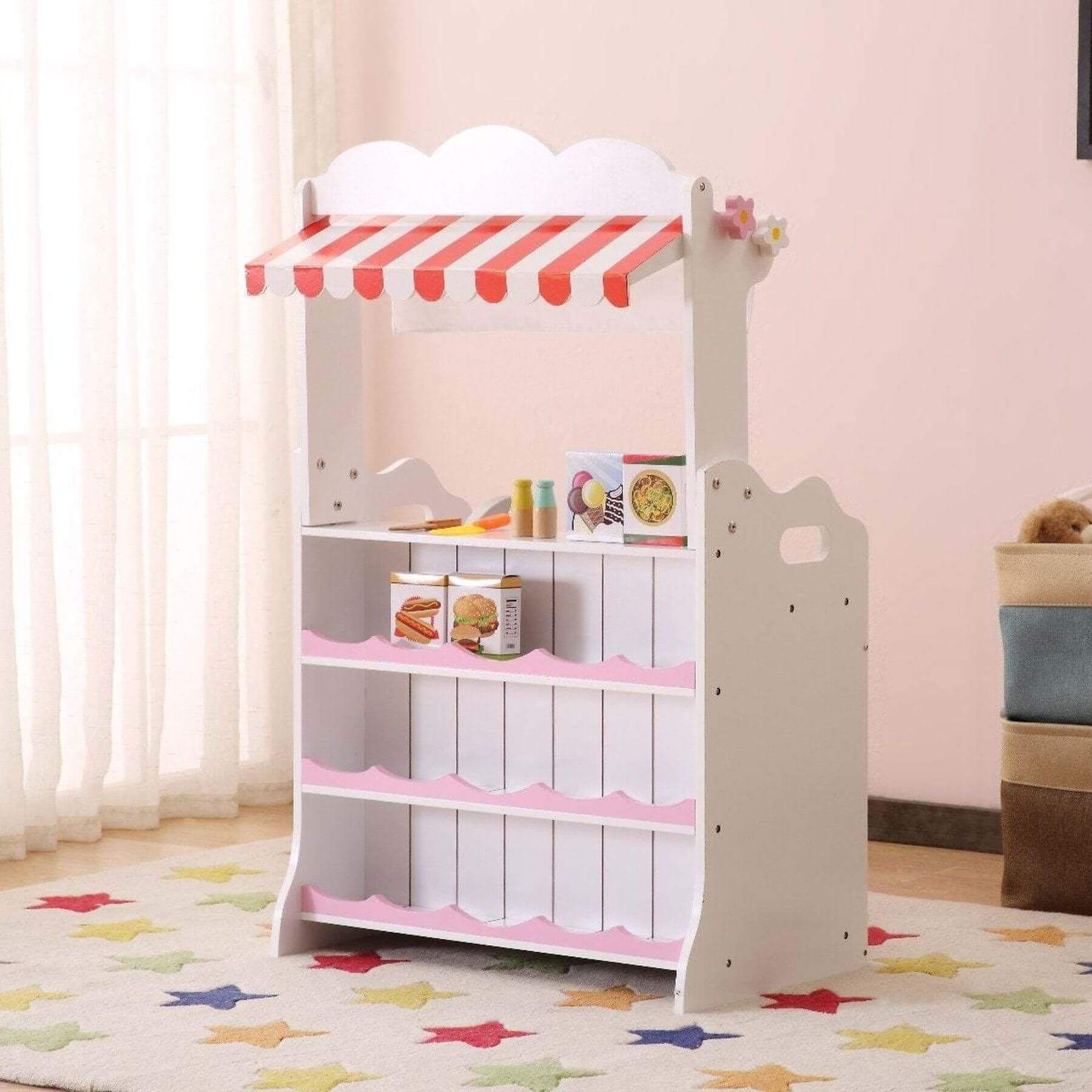 Kids Funnel 2 In 1 Pink Pretend Kitchen and Market Stall in a room with pink walls and colorful rug.