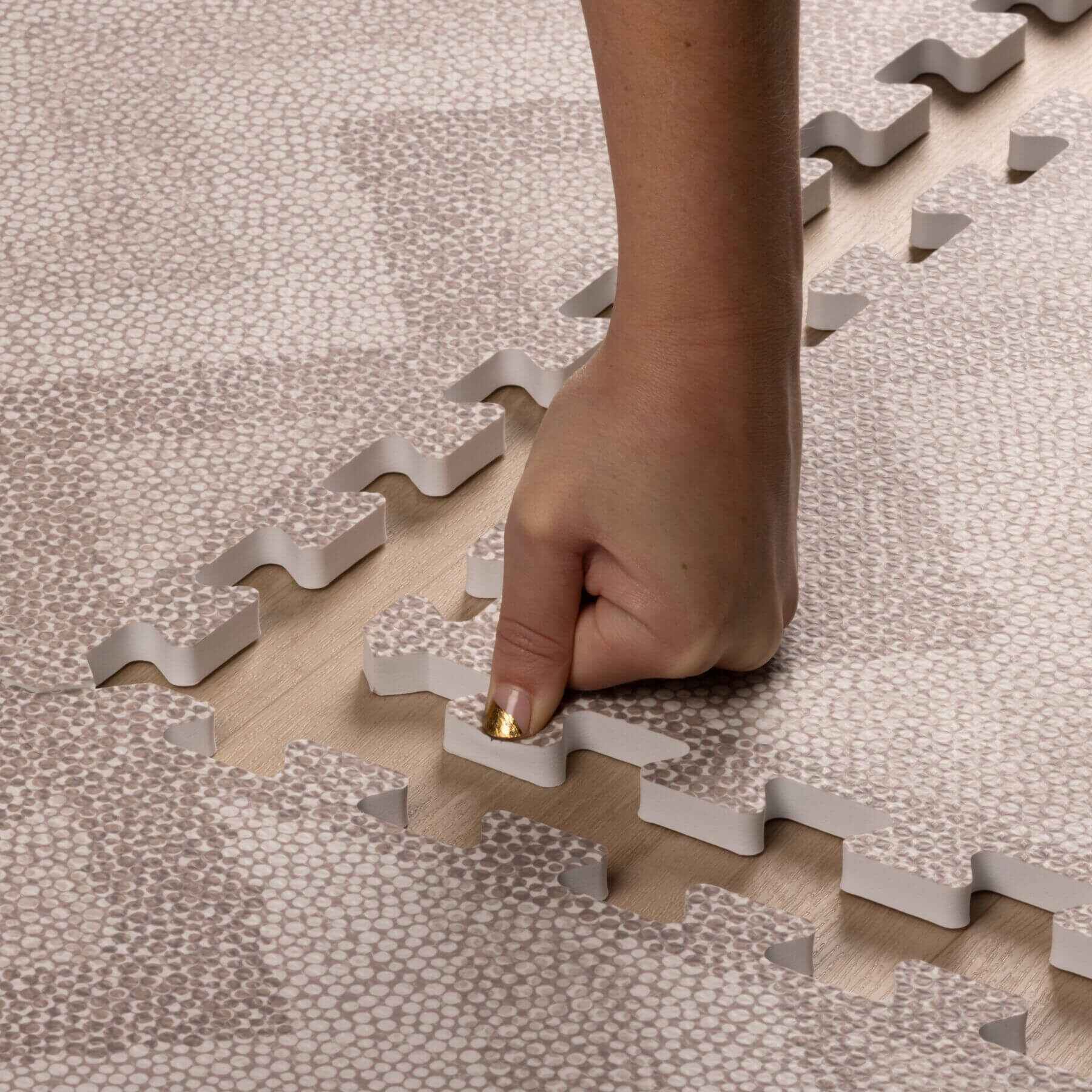 Hand placing Eeveve Kilim Play Mat - Dark Taupe